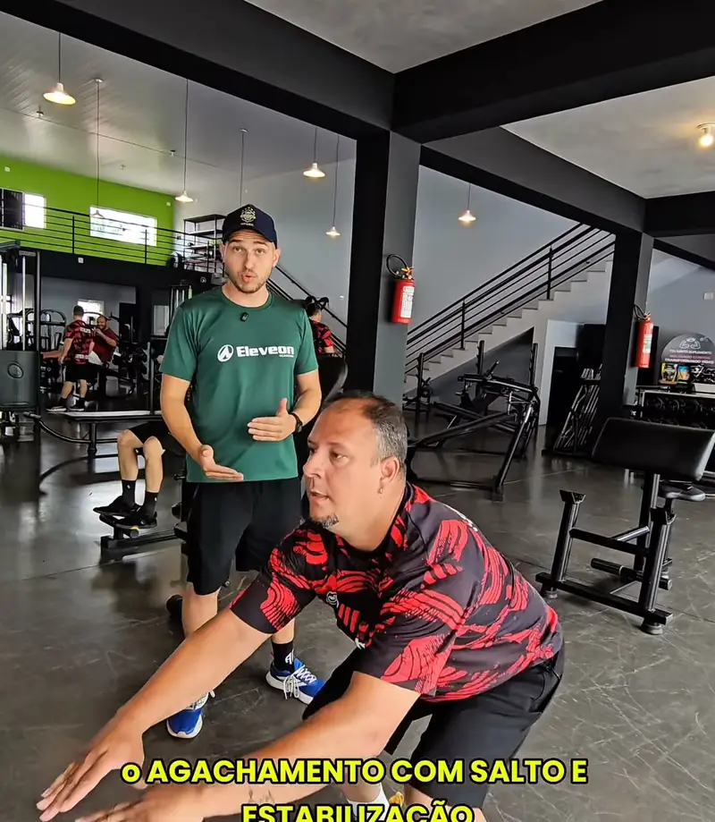 Aluno fazendo agachamento com salto sob orientação do professor